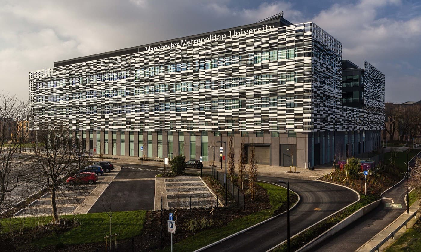 Siyah-beyaz cephe panelleriyle kaplı, üzerinde Manchester Metropolitan University yazan Brooks Building