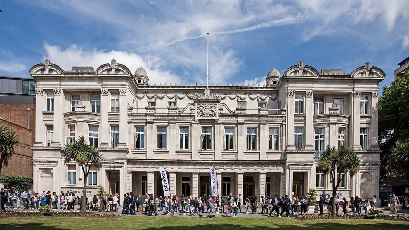 Queens’ Building’in taş cephesi ve önünde toplanan öğrenciler, Queen Mary Üniversitesi Mile End kampüsü